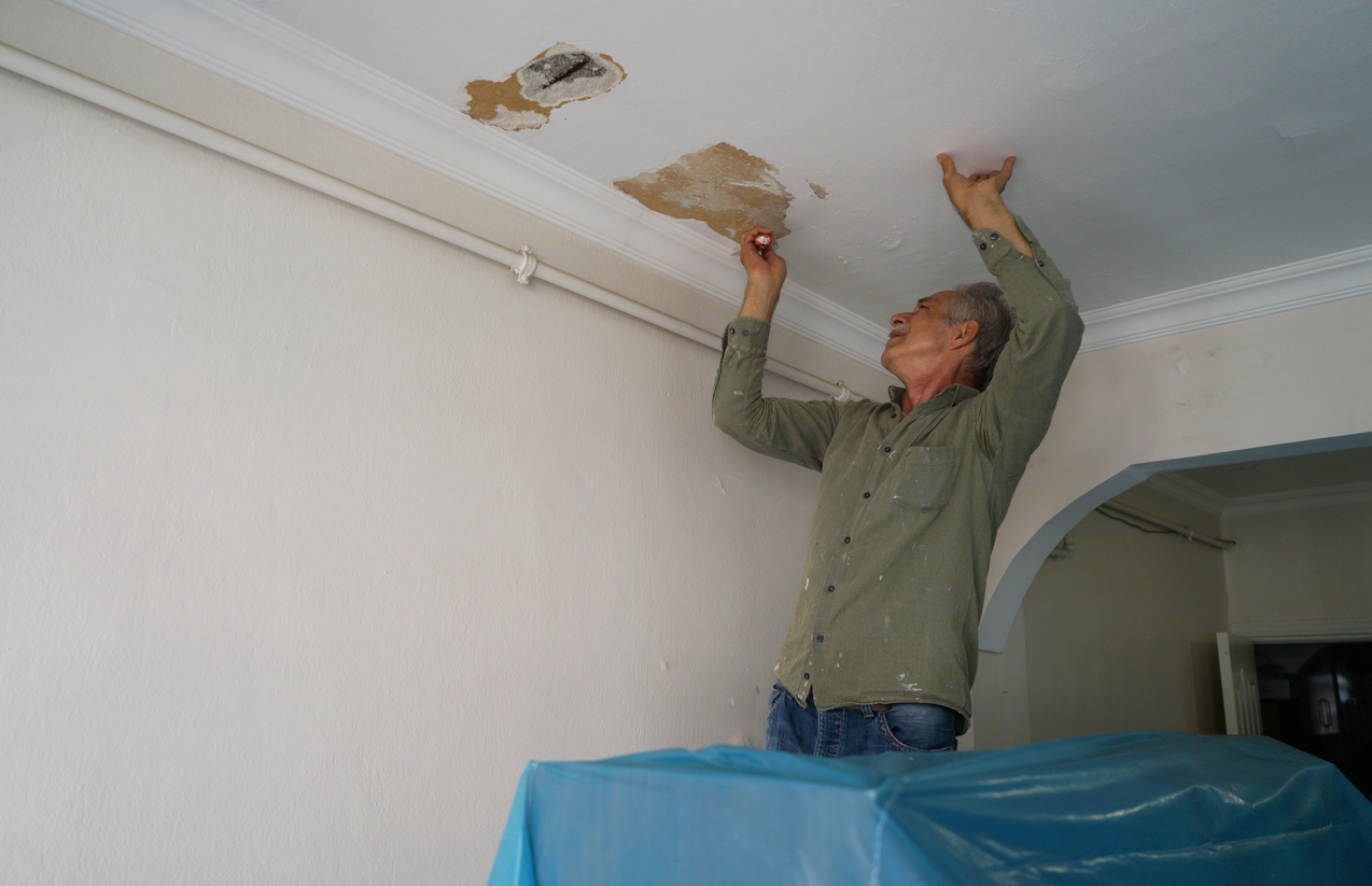 master scrapes walls with spatula